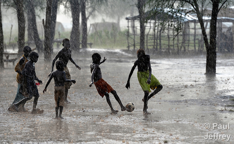 Children Playing Football In Rain