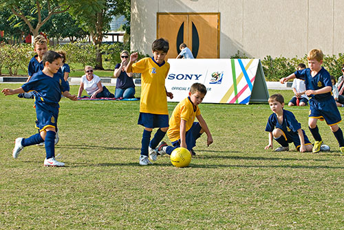 Children Playing Football At School